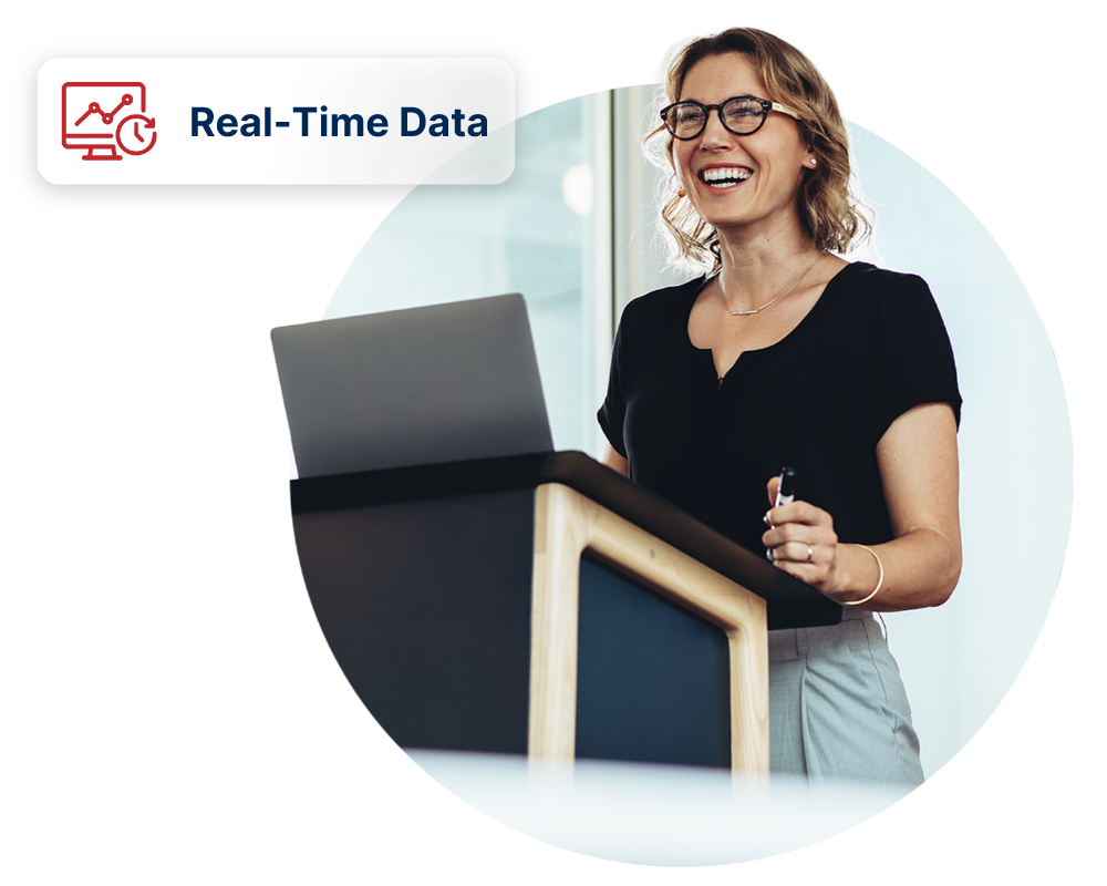 Female presenter standing at podium with laptop