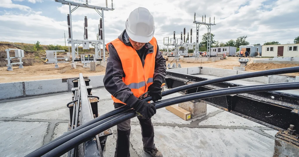 worker holding cable wire conduit